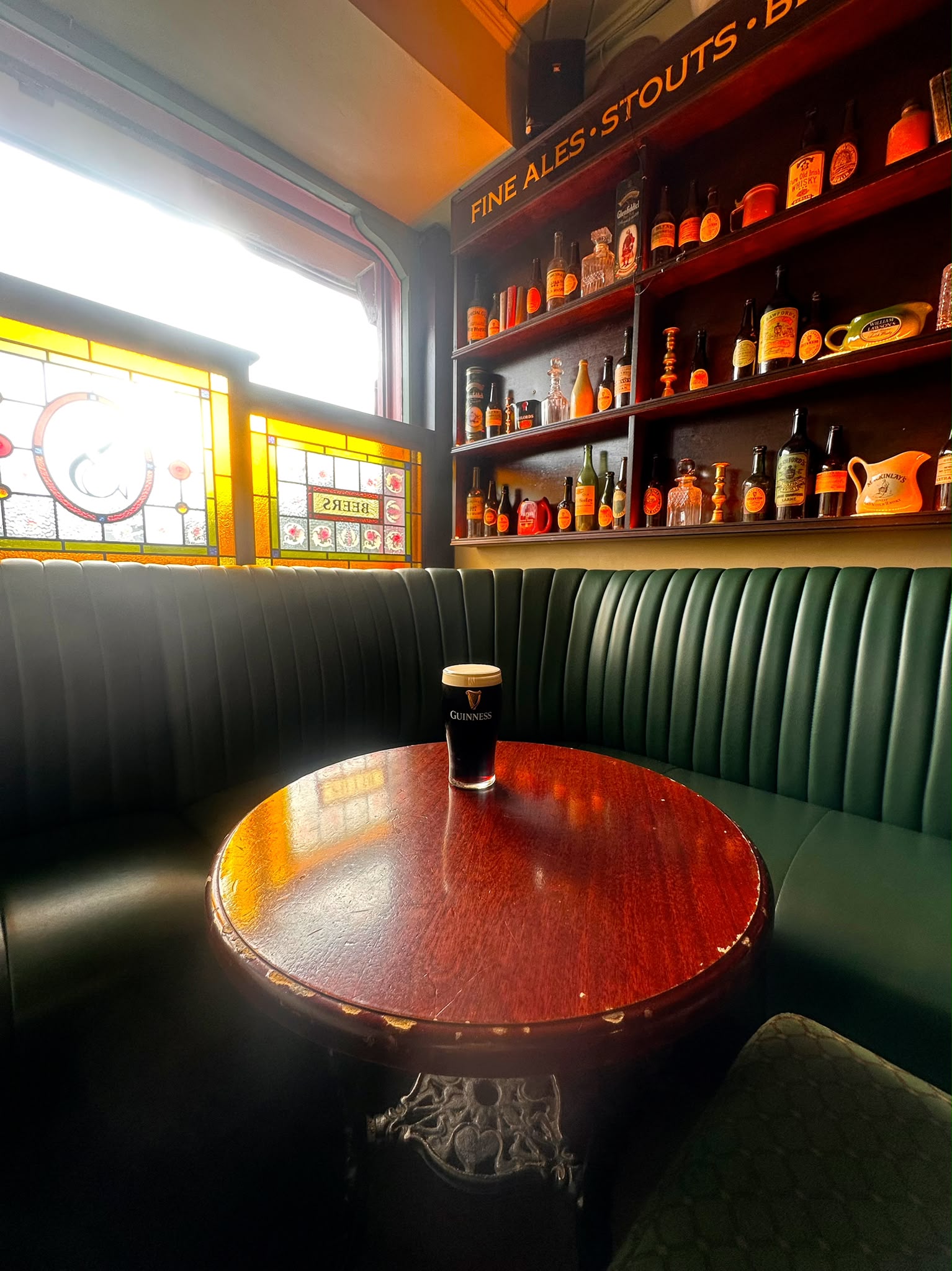A pint in the corner snug beside the stained-glass window